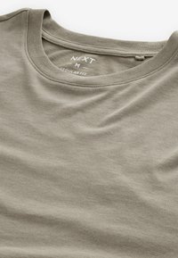 Olijfgroene katoen t-shirt met een ronde hals en korte mouwen. Licht zichtbare textuur, gelabeld "NEXT M REGULAR FIT" op de kraag.