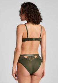 Olijfgroen lingeriesetje met een geribbelde stof en kantaccenten. Verstelbare banden, een bh met beugel en een hoog opgesneden ondergoed ontwerp.