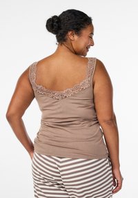 Braunes Trägershirt mit Spitzenrücken, breiten Trägern und figurbetontem Schnitt. Kombiniert mit gestreiften Pyjamahosen in hell- und dunkelbraun.