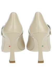 Beige Leder High Heels mit spitzem Zehenbereich und slim Stiletto-Absatz. Mit einem seitlichen Schnallendetail und einem glatten, glänzenden Finish.