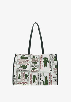 Weiße Tragetasche mit schwarzen Griffen, die wiederholt grüne Krokodil-Logos und roten sowie schwarzen Text mit der Aufschrift „Chemise Lacoste“ und verwandten Phrasen zeigt.