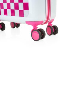 Maleta rígida con cuerpo blanco, patrón de cuadros rosa, detalles en rosa y cuatro ruedas negras para movilidad. Cierre con cremalleras a lo largo del borde.