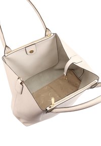 Lichtgrijze handtas van getextureerd leer, met gouden hardware en een ruime binnenkant die een zachte beige voering en een ritsvak toont.