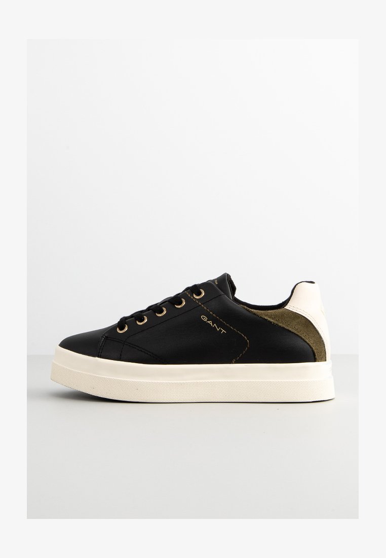 Schwarze Leder-Sneaker mit goldenen Augenringen, weißer Sohle und olivgrünen Akzenten an der Ferse. Verfügt über eine glatte Textur und ein schlichtes Design.