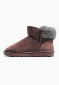Stivaletti in suede marrone con punta rotonda, dotati di un risvolto in pelliccia grigia, suola piatta e dettagli cuciti sulla tomaia.