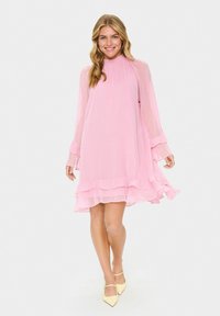 Ein pinkfarbener Chiffonkleid mit hohem Kragen, langen Ärmeln und gerafftem Saum. Die Textur ist leicht, fließend und hat geschichtete Akzente.