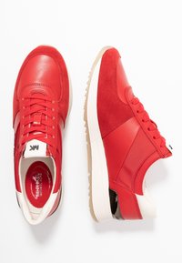 Baskets rouges composées d'un mélange de cuir lisse et de daim. Bout arrondi, semelle extérieure blanche contrastante, et accents texturés ajoutant du détail.