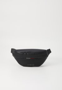 Black leather waist bag with a smooth texture, oval shape, and a zip closure. Features a small logo and red, white, and blue accents.