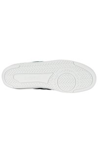 Podešev K-SWISS tenisky má bílou gumovou podrážku s texturovanými grip vzory. Světle zelené akcenty a logo vyryté na boku.