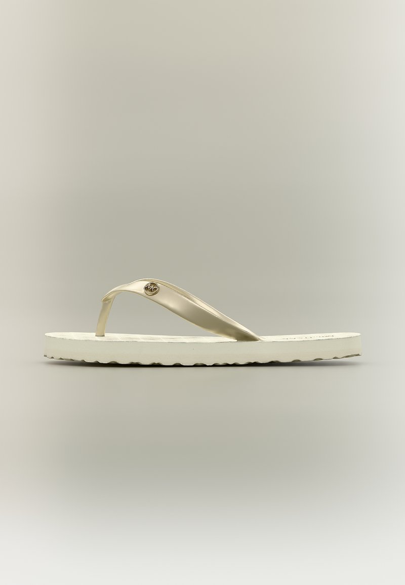 Μονό μπεζ σαγιονάρι με λεπτό λουράκι και μικρή μεταλλική λεπτομέρεια λογότυπου, σε ουδέτερο φόντο.