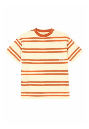 Ung dreng med blondt hår iført en beige og orange stribet t-shirt, cremefarvede bukser og lysebrune slip-on sko med spænder.