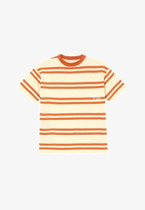 Jeune garçon aux cheveux blonds portant un t-shirt rayé beige et orange, un pantalon crème et des chaussures légères marron clair à enfiler avec des boucles.