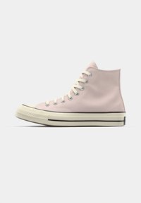 Høye sneakers i lys rosa lær med hvite lisser og gummisåle. Har svart stripe og teksturert tåhette.
