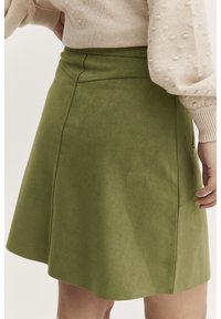 Grön faux suede A-linje kjol med en figurn�ära midja och subtil sidficka, med en slät textur och rena sömmar.
