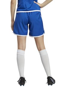Blaue Sportshorts mit weißen Akzenten, kombiniert mit knielangen weißen Socken und schwarzen Fußballschuhen. Glatter Stoff, leichtes Design.