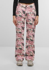 Rose camo cargo hlače s opuštenim krojem, koje sadrže dva bočna džepa i kombinaciju nijansi koje uključuju svijetlo ružičastu, bež i sivu.