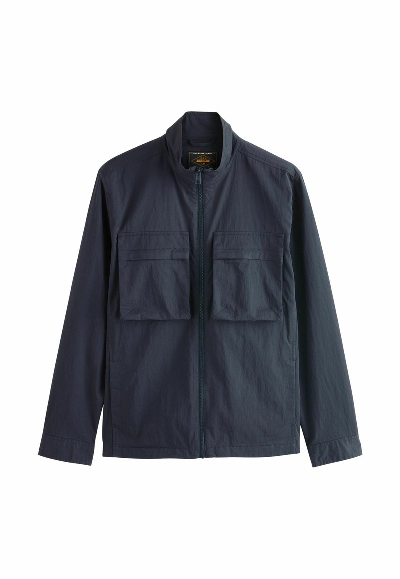 Giacca leggera di un blu scuro con zip frontale e due grandi tasche sul petto con patta, mostrata su uno sfondo bianco.
