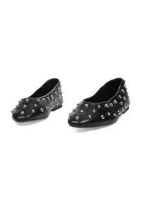 Bailarinas de imitación de cuero negro adornadas con tachuelas metálicas. Presentan una punta redondeada y un diseño de perfil bajo, con una textura suave y acentos mínimos.