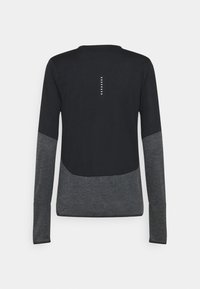 Svart långärmad skjorta med en mörkgrå nederdel, med ett centralt ryggmotiv av sex små vita prickar arrangerade vertikalt.