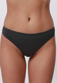 Čierny bavlnený bikiny s hladkým povrchom. Má nízky strih s elastickým pásom a minimálnym krytím.