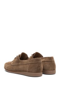 Scarpe in suede marrone con profilo basso, punta arrotondata e dettagli cuciti. Presentano una suola in gomma liscia e lacci nella parte anteriore.