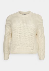 Kremowy, gruby sweter z dzianiny o długim rękawie i okrągłym dekolcie, z teksturowanym wzorem na całej powierzchni.