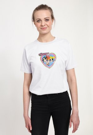 Weißes Baumwoll-T-Shirt mit einem bunten, glitzernden Herzgrafik, das drei Cartoonfiguren und Text zeigt. Schwarze Jeans werden zum Shirt getragen.