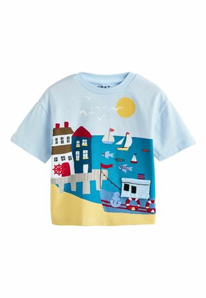 Blaues T-Shirt mit einem Küstenszene-Motiv, das Häuser, ein Boot, Fische und eine Sonne zeigt. Aus Baumwolle, mit bunten Stickereien und kurzen Ärmeln.