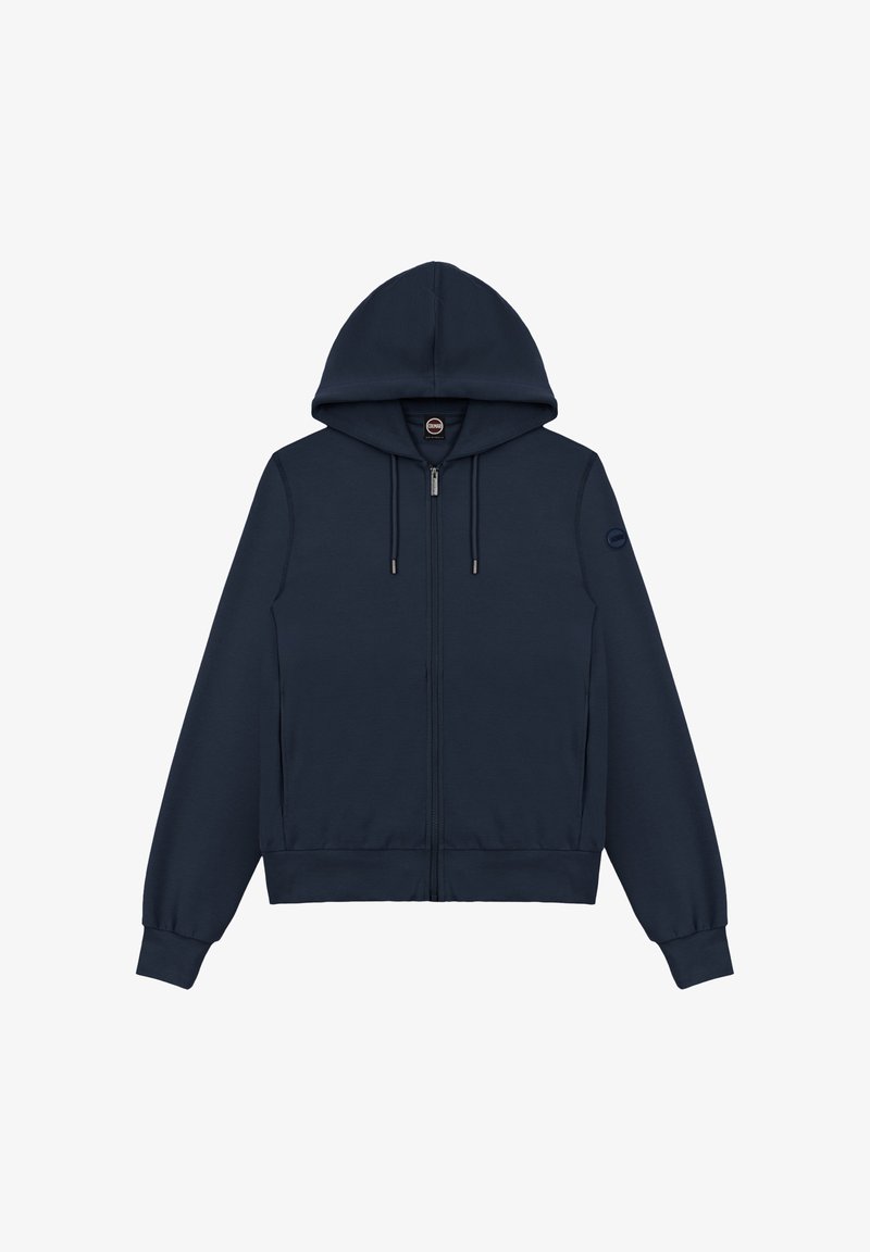 Sweat à capuche zippé bleu marine avec cordons de serrage, poignets et ourlet côtelés, et un petit patch logo rond sur la manche gauche.