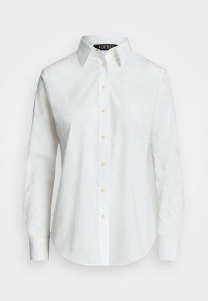 Chemise blanche à boutons, en coton lisse, avec un col classique, présentant un ourlet droit et des boutons beiges le long du devant.