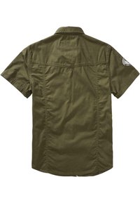 Chemise manches courtes vert olive avec un col, des coutures visibles et un patch logo rond sur la manche gauche, vue de dos.