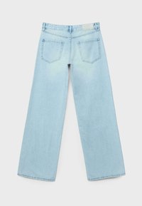 Lyseblå jeans med vide ben lavet af denim med en slidt struktur. Har to baglommer og en etiket på linningen bagpå.