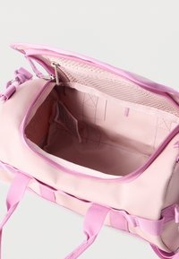 Odprta svetlo roza potovalna torba, ki prikazuje prazno notranjost z mrežastim žepom in dvema roza ročajema na belem ozadju.
