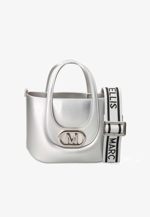 Sac à main argenté avec doubles poignées, rabat avant avec un emblème métallique « M » et une bandoulière ajustable noire et blanche avec du texte.