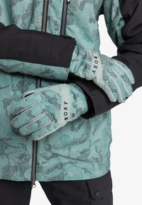 Turquoise gloves with a floral pattern and black accents. The gloves feature a snug fit and adjustable wrist closure for comfort.