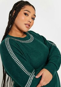 Maglione verde lavorato a maglia con maniche lunghe, caratterizzato da accenti di perline argentate lungo il colletto e le maniche, tessuto testurizzato e vestibilità over.