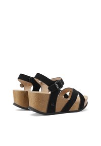 Sandali con zeppa in suede nero e piattaforma in sughero, caratterizzati da molteplici cinturini incrociati e un cinturino alla caviglia con fibbia per una vestibilità sicura.