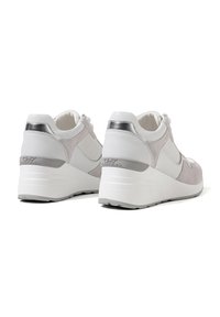 Sneakers bianchi e grigio chiaro con pannelli in suede e mesh, dettagli argentati e suola a zeppa. Presentano lacci e branding sul tallone.