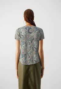 Top cu mânecă scurtă dintr-un material moale, cu un model paisley în nuanțe de verde, bleumarin și roz, cu margine curbată și o croială lejeră.