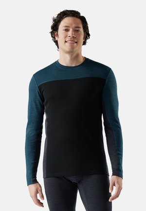 Zwart met teal accenten op de schouders en mouwen, langemouwen T-shirt. Gemaakt van een zachte, rekbare stof. Ronde halslijn.