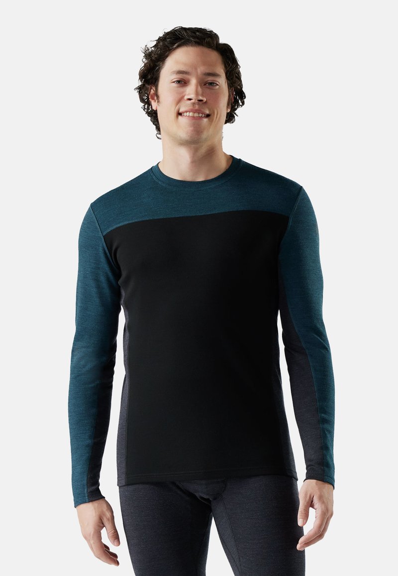 Long-sleeve shirt in black with teal accents on shoulders and sleeves. Made from a soft, stretchable fabric. Rounded neckline.