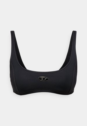 Melns sporta krūšturis ar platām lencēm, gludu dizainu un pieguļošu formu. Priekša dekorēta ar nelielu logotipu un teksturētu šuvi.