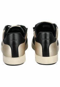 Sneaker neri e oro con superficie in pelle liscia, texture a contrasto e design a profilo basso. Include il logo del marchio sul retro.