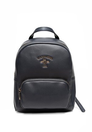 Zaino in pelle nera con superficie texturizzata, hardware dorato, tasca frontale con zip e manico superiore. Presenta un logo in rilievo sulla parte anteriore.