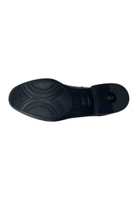 Suola di scarpa in gomma nera con un motivo testurizzato, caratterizzata da disegni circolari e lineari, e un accento circolare prominente vicino al tallone.