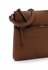 Borsa a tracolla in pelle marrone con una texture liscia, tasca con cerniera e una tracolla regolabile. Presenta il marchio sulla parte anteriore.