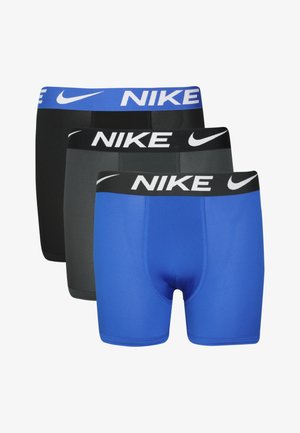 Drie paar Nike boxershorts in zwart, grijs en blauw. Elk heeft een elastische tailleband met het "Nike" logo in contrasterende kleuren.