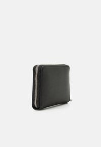 Black leather wallet with a textured surface, rectangular shape, and silver zipper detail along one edge. Minimalist design.