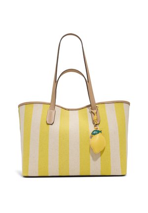 Torba na ramię w żółto-beżowe pionowe paski z jasnobrązowymi skórzanymi uchwytami i breloczkiem w kształcie cytryny zawieszonym na jednym uchwycie.