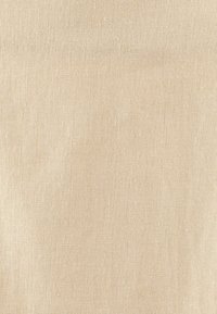 Beige linne tyg med en strukturerad yta och ett naturligt vävmönster, lämplig för kläder eller möbelklädsel.